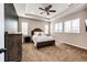 Inviting main bedroom featuring a ceiling fan, tray ceiling, and multiple windows for natural light at 3966 Long Rifle Dr, Castle Rock, CO 80108