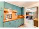 Kitchen with blue cabinets, wooden countertop, tile backsplash, and wood-look flooring at 6051 Ivanhoe St, Commerce City, CO 80022