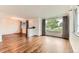Bright living room featuring hardwood floors, large windows, and elegant chandelier at 6051 Ivanhoe St, Commerce City, CO 80022