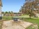 A backyard featuring a concrete patio with seating and grass at 8267 High St, Denver, CO 80229