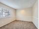 Cozy carpeted basement featuring neutral walls, updated lighting, and a large window at 8267 High St, Denver, CO 80229