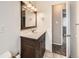 Bathroom featuring a single sink vanity, a decorative mirror and a view to the carpeted bedroom beyond at 8267 High St, Denver, CO 80229