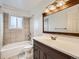 Bathroom with a vanity, tile backsplash, shower and tub combo, and tile floors at 8267 High St, Denver, CO 80229