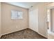 Bright bedroom with neutral carpet, a window, and a built in closet near the bathroom entrance at 8267 High St, Denver, CO 80229