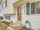 Inviting front entrance showcasing a glass door, green shutters, and a verdant green hose at 8267 High St, Denver, CO 80229