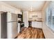 Galley kitchen featuring stainless steel appliances, white cabinets, and wood-look flooring at 8267 High St, Denver, CO 80229