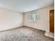 Cozy living room featuring neutral walls, carpet flooring, and a bright window at 8267 High St, Denver, CO 80229