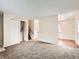Open living room featuring neutral walls, plush carpet, with an open stairway and entry into another room at 8267 High St, Denver, CO 80229