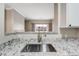 Kitchen sink featuring granite countertops and stainless steel faucet, looking out into living area at 7483 S Quail Cir # 626, Littleton, CO 80127