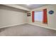 Basement bedroom with neutral carpet, a window with red curtains, and ample natural light at 6812 Indian Paintbrush St, Frederick, CO 80530