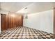Spacious basement featuring wood paneling, checkered flooring, and a window at 7172 Kalamath St, Denver, CO 80221