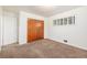 A bright bedroom, features a large closet, plush carpeting, and a window for a comfortable space at 7172 Kalamath St, Denver, CO 80221