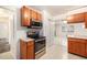 Functional kitchen featuring wooden cabinets, stainless steel appliances, and a pass-through window at 7172 Kalamath St, Denver, CO 80221