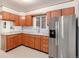 Well-equipped kitchen with wooden cabinets, stainless steel refrigerator, and a window view at 7172 Kalamath St, Denver, CO 80221