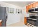 Kitchen featuring stainless steel appliances, wood cabinets, and a pass-through window at 7172 Kalamath St, Denver, CO 80221