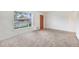 Inviting living room with large windows, neutral carpet, and a classic wooden door at 7172 Kalamath St, Denver, CO 80221