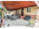 Charming covered patio area with outdoor seating and a brick exterior at 7172 Kalamath St, Denver, CO 80221