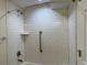 Clean bathroom featuring white subway tiles, a shower niche, and a convenient grab bar at 1152 S Eaton St, Lakewood, CO 80232