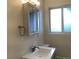 Bathroom sink with vanity and mirror, well-lit by overhead lighting and window at 1152 S Eaton St, Lakewood, CO 80232