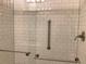 Bathroom shower featuring white subway tile and safety assist bars and glass door at 1152 S Eaton St, Lakewood, CO 80232