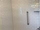 Bathroom shower featuring white subway tile and a convenient grab bar at 1152 S Eaton St, Lakewood, CO 80232