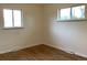 Well-lit bedroom featuring hardwood floors and two windows providing ample natural light at 1152 S Eaton St, Lakewood, CO 80232