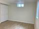 Basement bedroom with wood grain flooring, bi-fold closet, and a window at 1152 S Eaton St, Lakewood, CO 80232