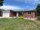 This single-story brick home features a well-manicured lawn, attached garage and a welcoming entrance at 1152 S Eaton St, Lakewood, CO 80232