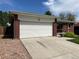 Attached brick home garage with a large white door and ample driveway parking at 1152 S Eaton St, Lakewood, CO 80232