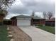 Charming brick home with a spacious driveway, attached garage, and well-maintained lawn at 1152 S Eaton St, Lakewood, CO 80232