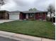Charming single-story brick home featuring an attached garage and well-maintained front lawn at 1152 S Eaton St, Lakewood, CO 80232
