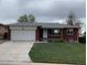 Charming single-story brick home featuring an attached garage and well-maintained front lawn at 1152 S Eaton St, Lakewood, CO 80232