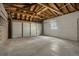 Expansive garage interior featuring concrete floor and walls, exposed ceiling, and a multi-panel garage door at 1152 S Eaton St, Lakewood, CO 80232