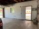 Spacious garage interior featuring concrete flooring, a side entry door and a window at 1152 S Eaton St, Lakewood, CO 80232