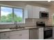 Bright kitchen with white cabinets, granite countertops, and stainless steel appliances at 1152 S Eaton St, Lakewood, CO 80232
