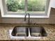 Close up view of a sink with granite countertop and a view of the yard from a window at 1152 S Eaton St, Lakewood, CO 80232