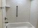 Bathroom shower and tub with white subway tile walls and brushed nickel fixtures at 1152 S Eaton St, Lakewood, CO 80232