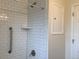 Updated shower featuring subway tile, grab bar, and shower accessories at 1152 S Eaton St, Lakewood, CO 80232