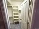 Walk-in closet with shelves and hanging rods for maximum storage, carpeted floor, and a white door at 22148 Red Hawk Ln, Golden, CO 80401
