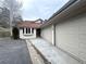 Exterior view of a stucco home with a terracotta roof and two-car garage, a paved driveway, and mature trees at 22148 Red Hawk Ln, Golden, CO 80401