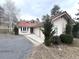 Exterior view of a stucco home with a terracotta roof, a two-car garage, mature trees, and a paved driveway at 22148 Red Hawk Ln, Golden, CO 80401