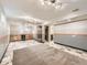 Finished basement area featuring a kitchenette, tile flooring, and ample lighting at 11707 W 65Th Cir, Arvada, CO 80004