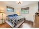 Inviting bedroom with two windows, wood floors, and a classic quilt at 11707 W 65Th Cir, Arvada, CO 80004