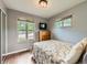 Neutral bedroom with two large windows, wood floors, and simple furniture at 11707 W 65Th Cir, Arvada, CO 80004
