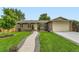 Well-maintained brick home with a lush lawn, mature trees, and an inviting walkway at 11707 W 65Th Cir, Arvada, CO 80004