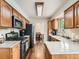 Modern kitchen featuring oak cabinets, gray quartz countertops, and stainless steel appliances at 11707 W 65Th Cir, Arvada, CO 80004