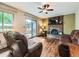 Comfortable living room with a brick fireplace, hardwood floors, and sliding glass doors to the backyard patio at 11707 W 65Th Cir, Arvada, CO 80004
