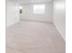 A spacious basement area with neutral carpet, large window, and a door leading to another part of the house at 45 W Fremont Pl, Littleton, CO 80120