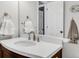 Bright bathroom featuring white quartz countertops and sink, plus a dark wood vanity and brushed metal fixtures at 45 W Fremont Pl, Littleton, CO 80120