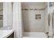 Bathroom with gray stone tiling has a bathtub-shower combo, plus white curtain and light-colored towels at 45 W Fremont Pl, Littleton, CO 80120